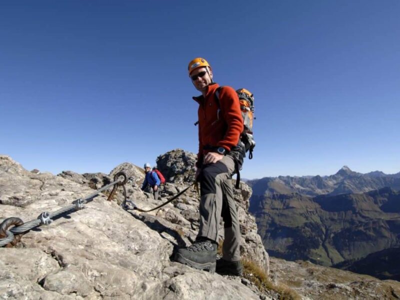 Kletterer im Klettersteig freu sich über traumhaften Panoramablick