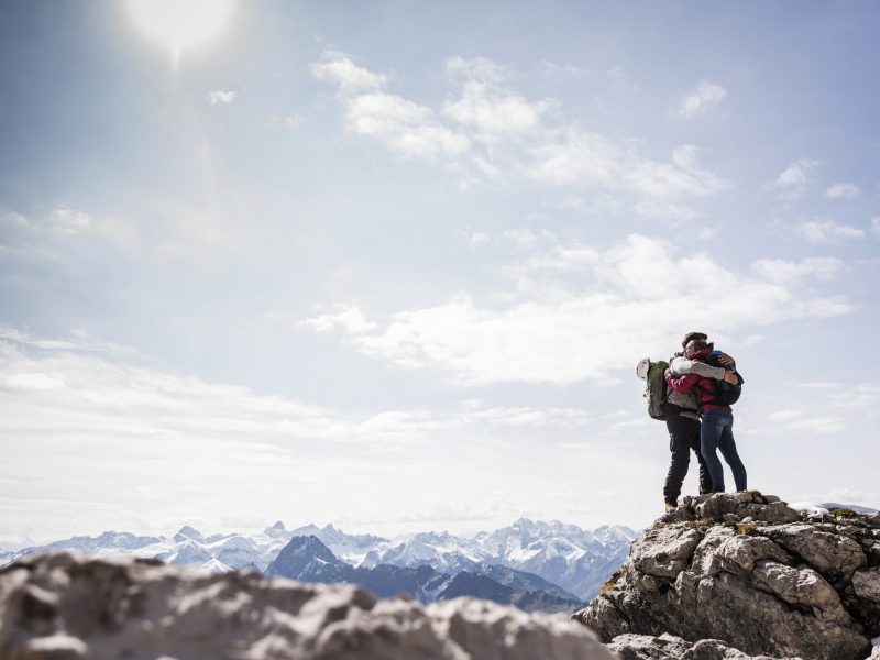 Germany, Bavaria, Oberstdorf, couple hugging on rock in alpine scenery Germany, Bavaria, Oberstdorf, couple hugging on rock in alpine scenery